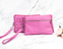 Two pink handbags with a wristlet on a marble surface