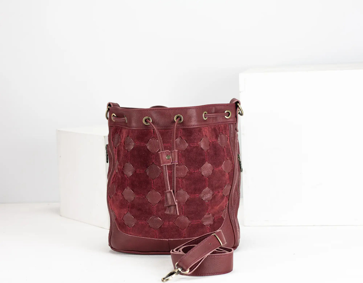 Red textured handbag with a strap on a white background