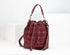 Maroon handbag with gold accents on a white background