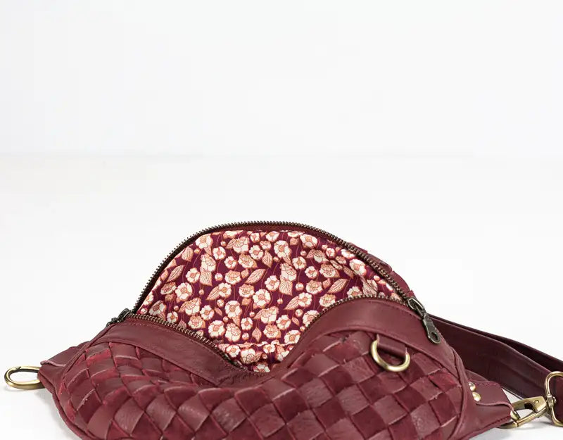 Maroon woven handbag with floral interior on a white background