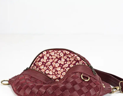 Maroon woven handbag with floral interior on a white background