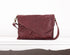Maroon leather handbag on a white background