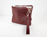 Maroon woven handbag with floral interior on a white background