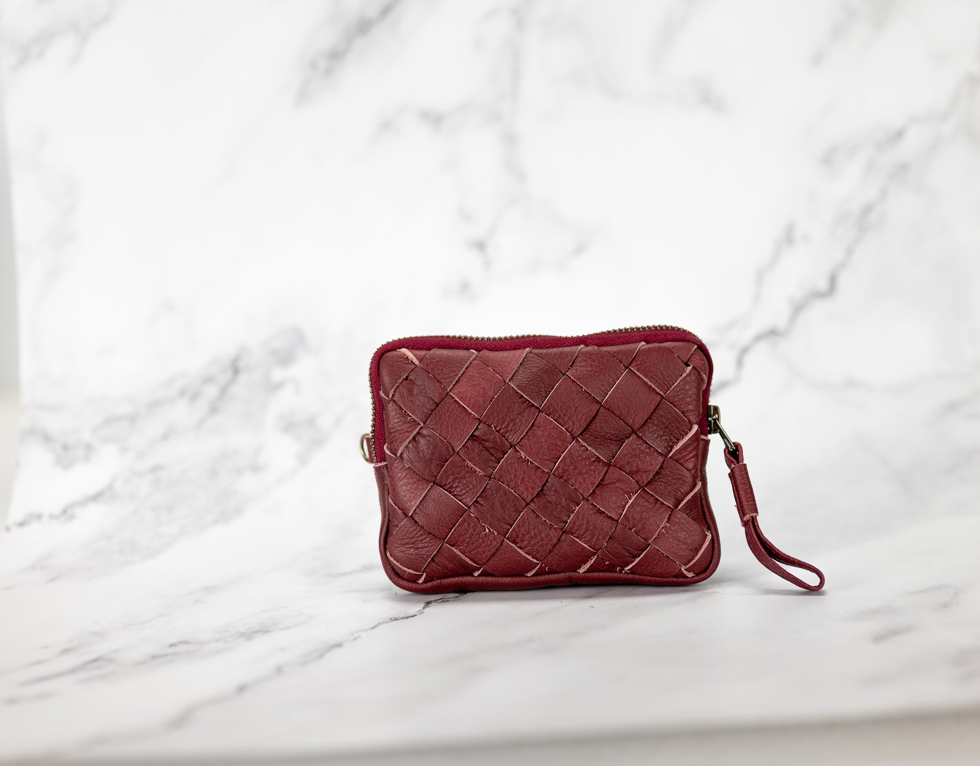 Red woven handbag on a marble surface