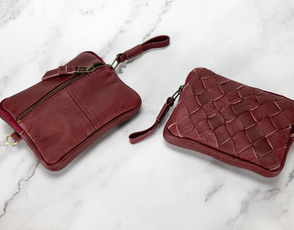 Two red leather bags on a marble surface