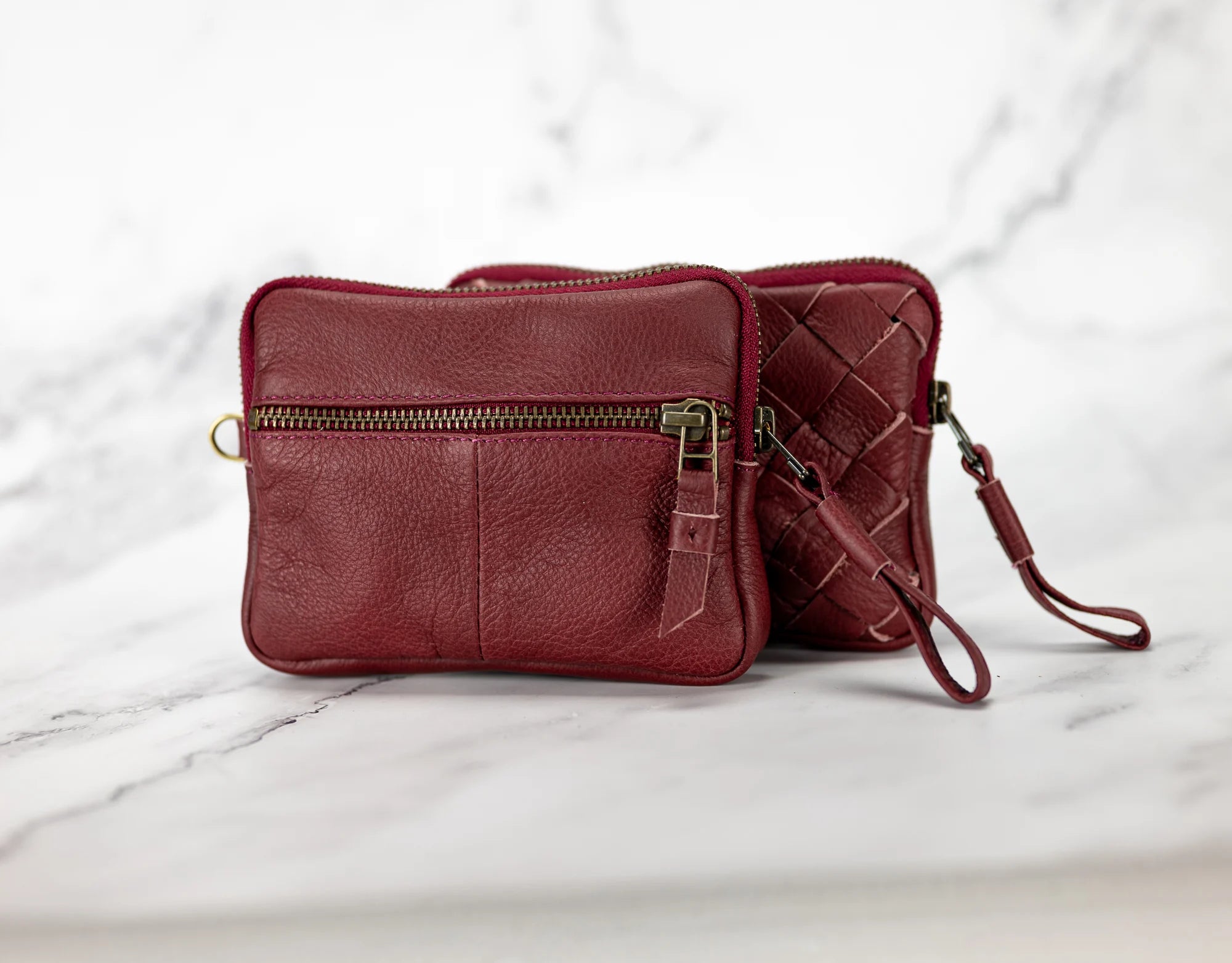 Red leather handbag with a strap on a marble surface