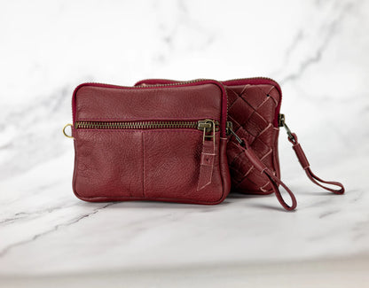 Red leather handbag with a strap on a marble surface