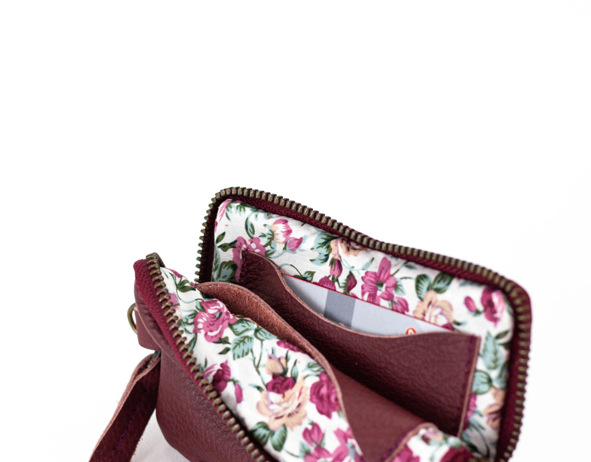 Floral-patterned bag with a visible brand name on a white background#color_burgundy