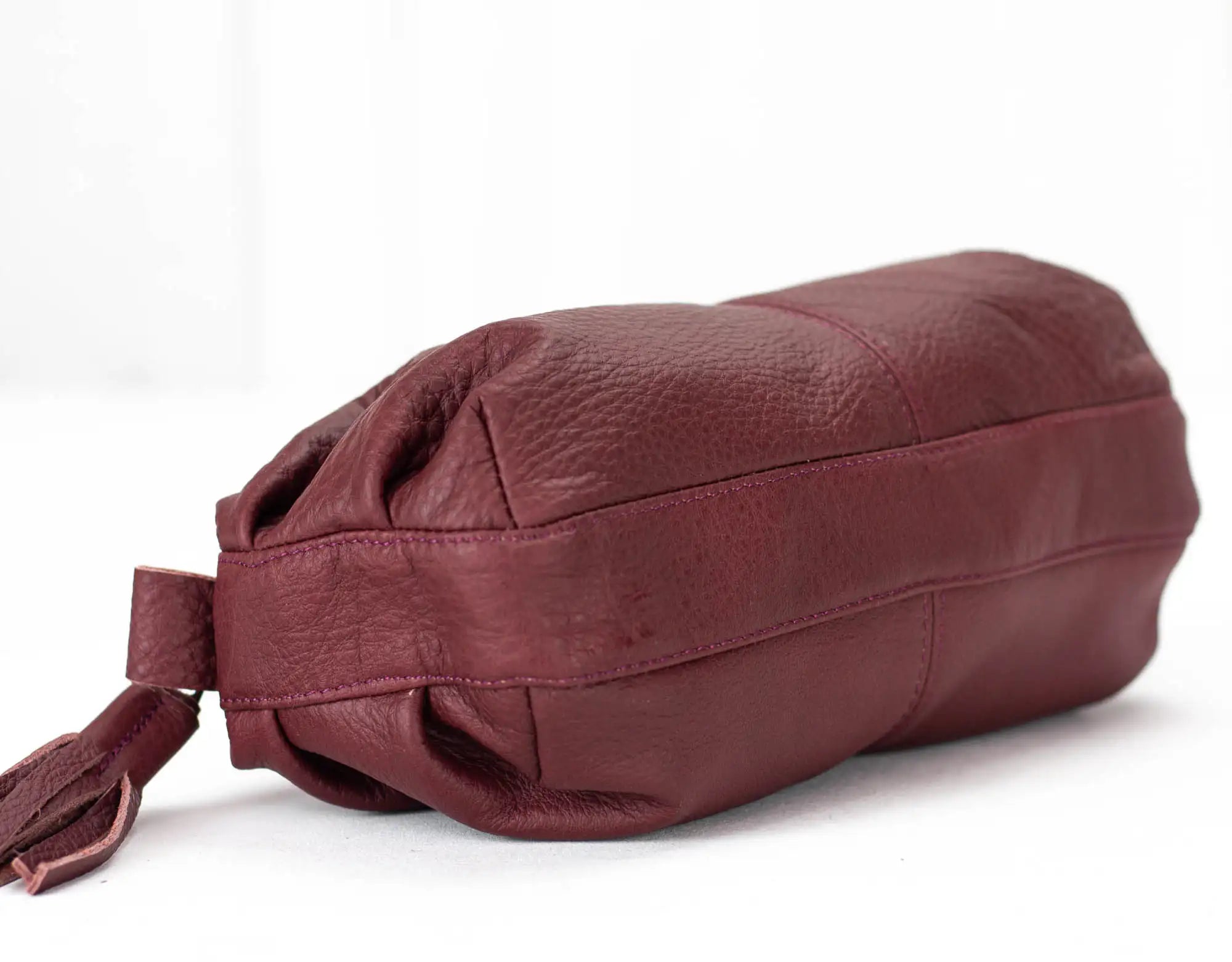 Maroon leather bag on a white background