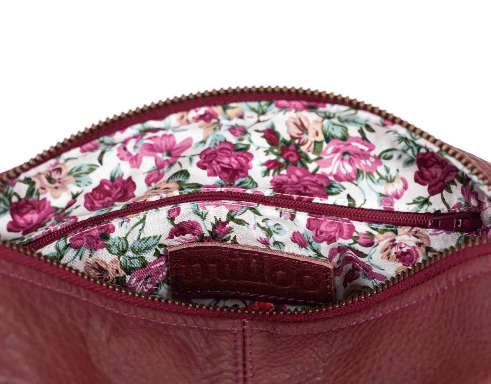 Floral-patterned interior of a pink handbag with visible brand name.