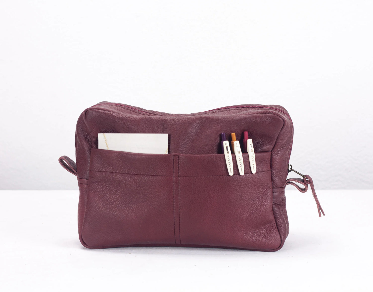 Maroon leather pouch with compartments on a white background