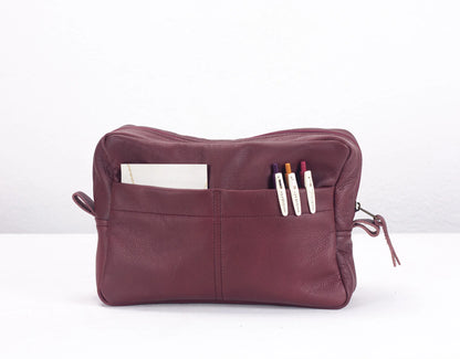 Maroon leather pouch with compartments on a white background