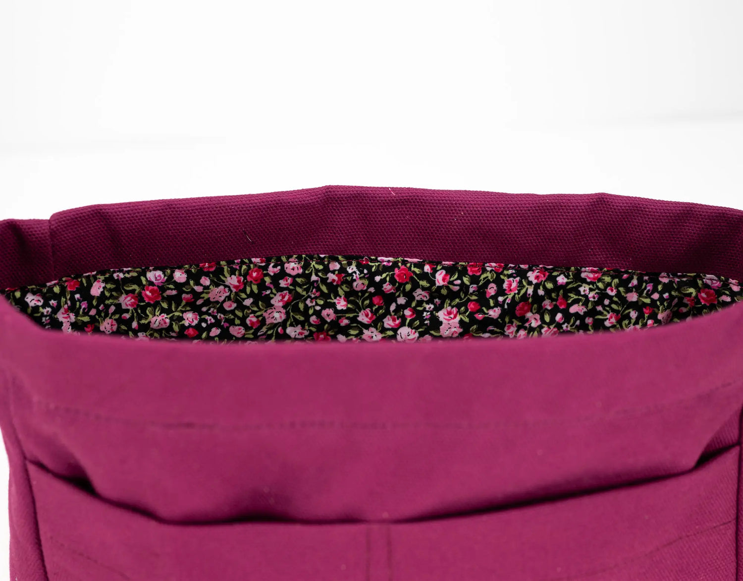 Close-up of a purple bag with a floral lining on a white background