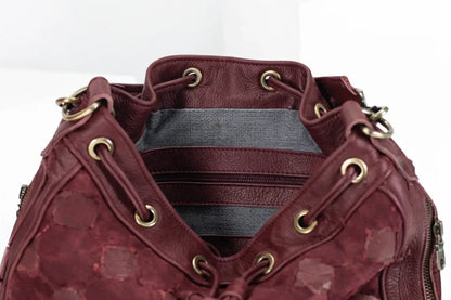 Maroon leather bag with gold accents on a white background