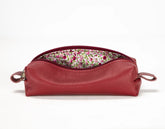 Red leather pouch with floral lining on a white background