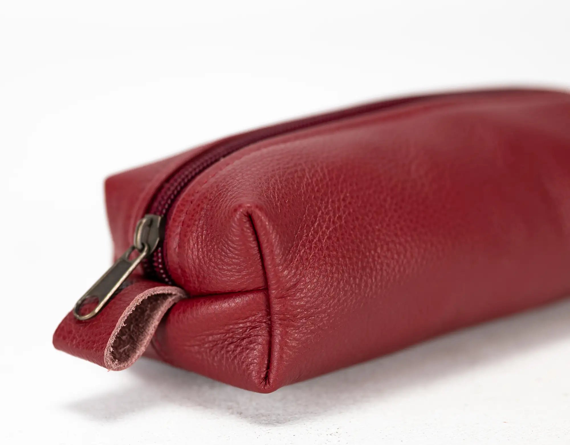Red leather pouch with a zipper on a white background