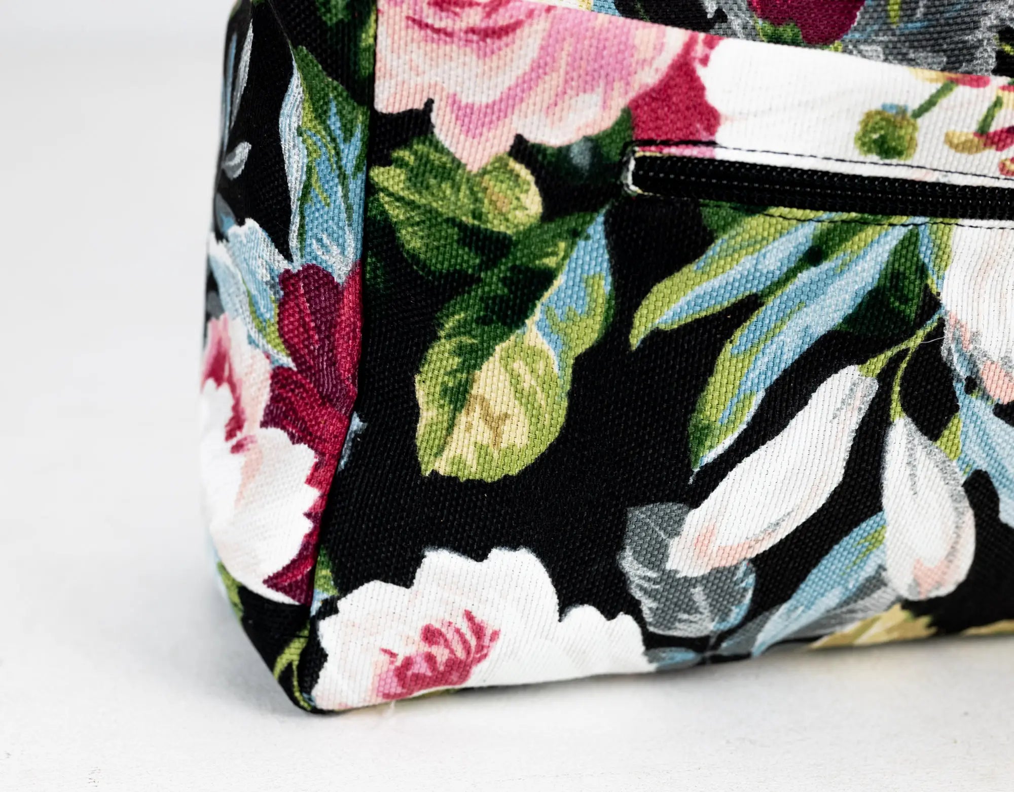 Floral patterned bag with a strap on a light gray background
