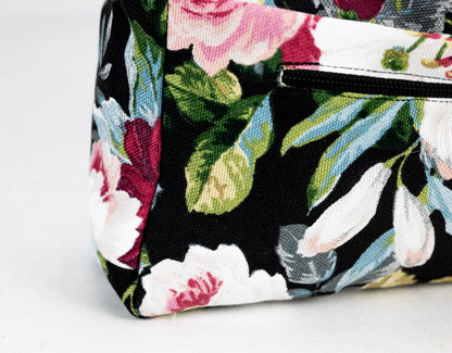 Floral patterned bag with a strap on a light gray background