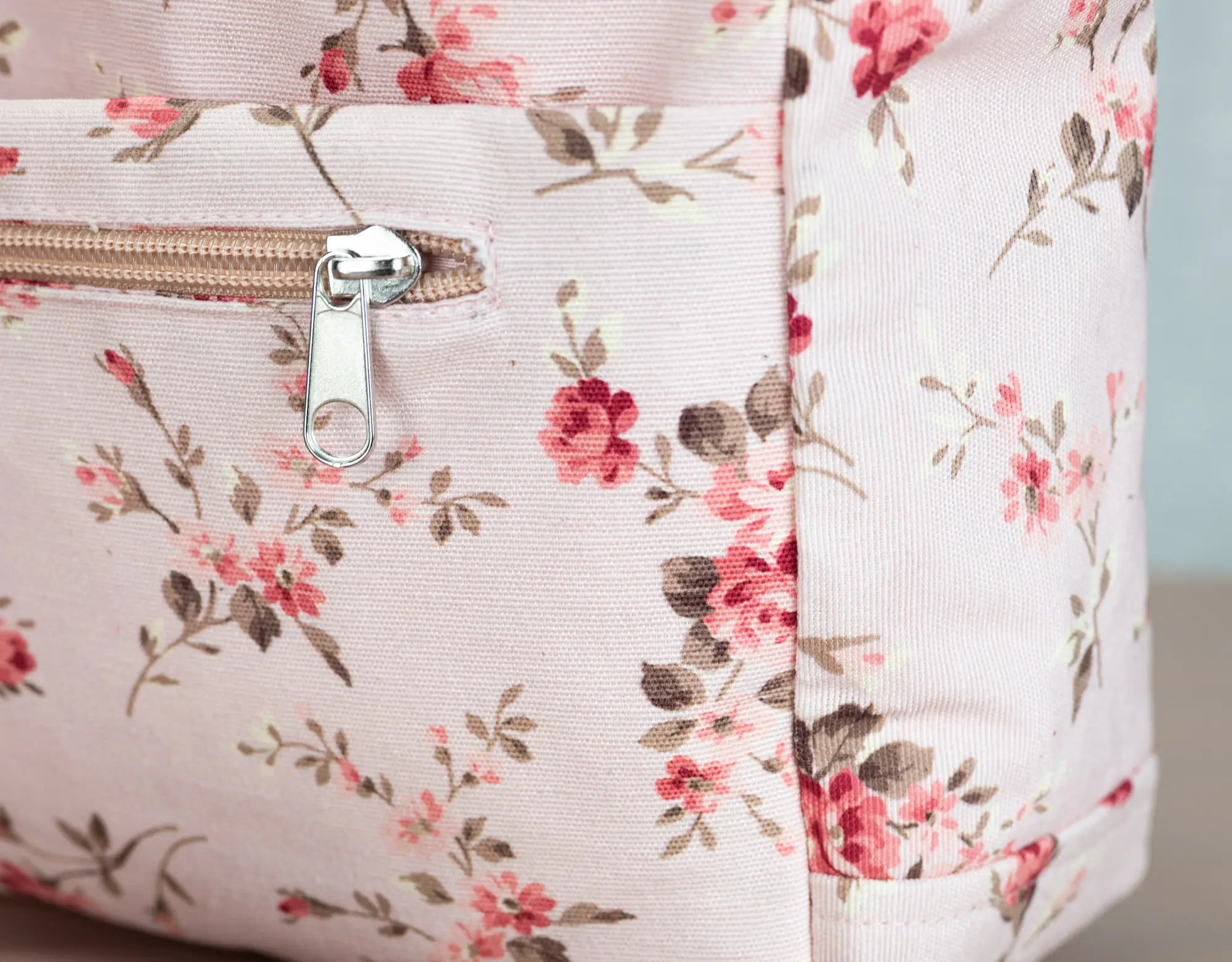 Floral-patterned bag with a zipper on a light background