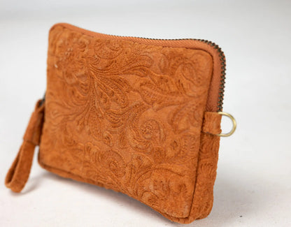 Brown leather clutch with intricate patterns on a white background