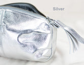 Silver clutch bag with a tassel on a light background