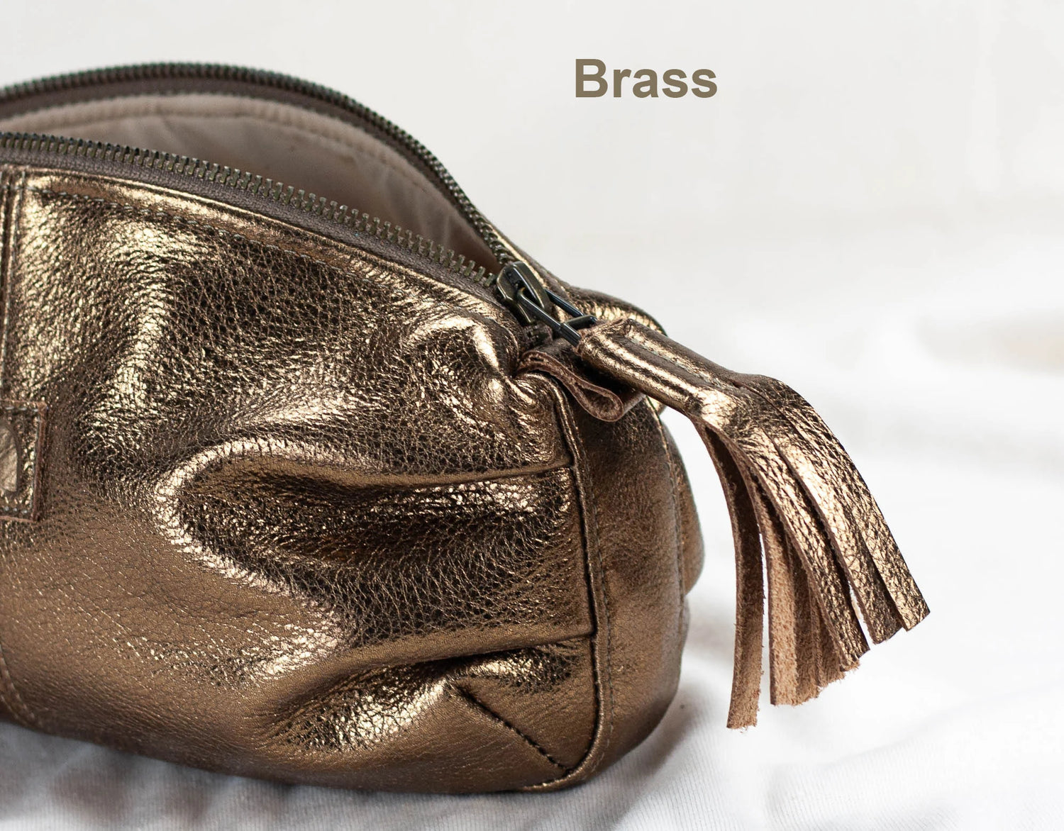 Gold metallic pouch with a tassel on a light background