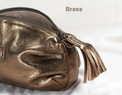 Gold metallic pouch with a tassel on a light background