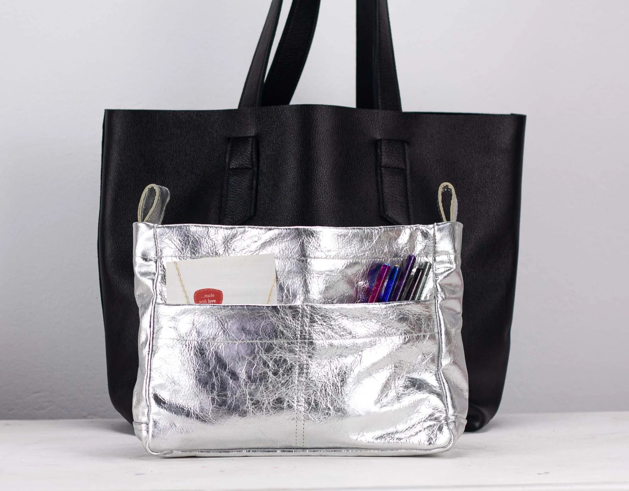 Silver bag insert with a silver pocket on a light gray background