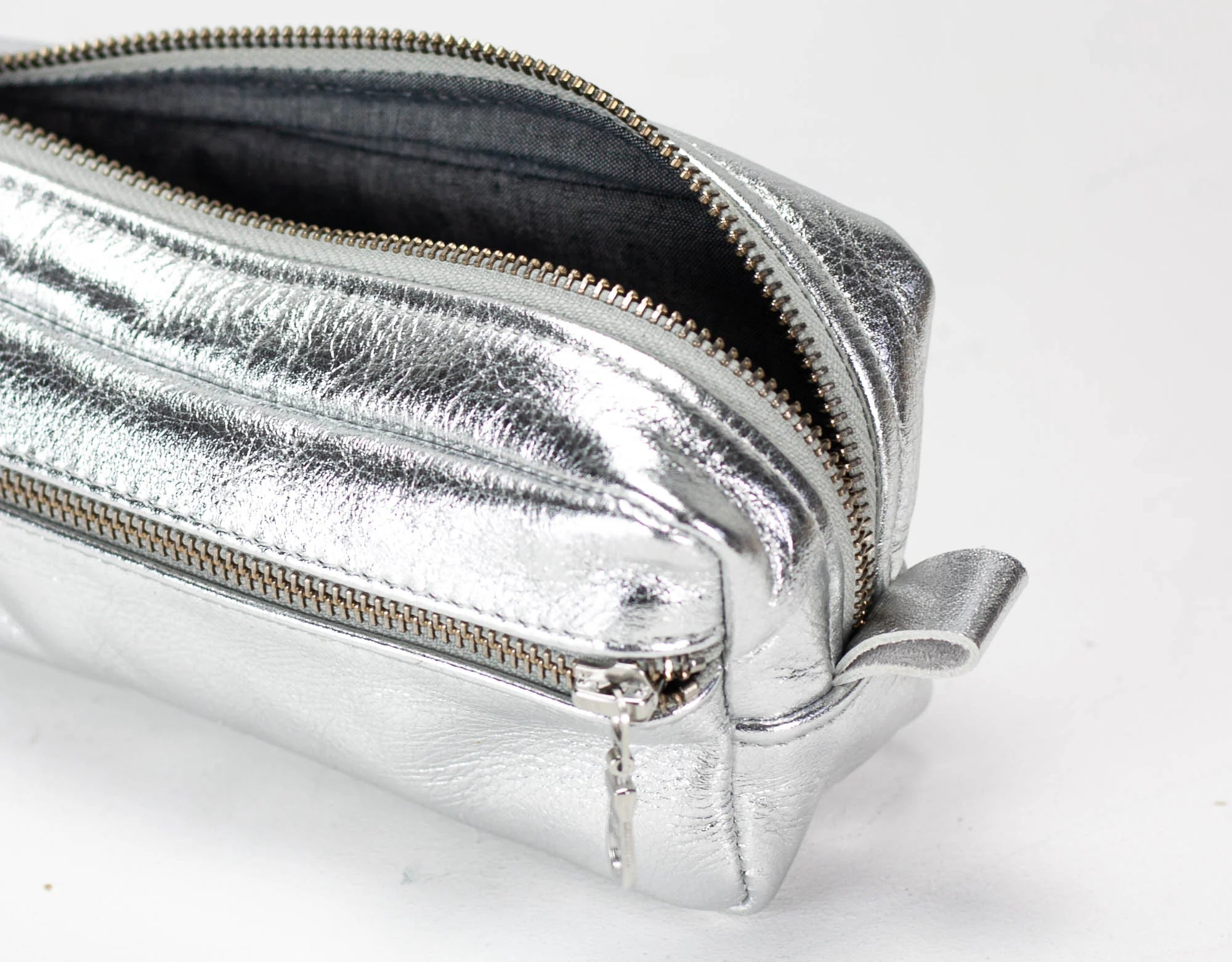 Silver metallic pouch with a zipper on a white background