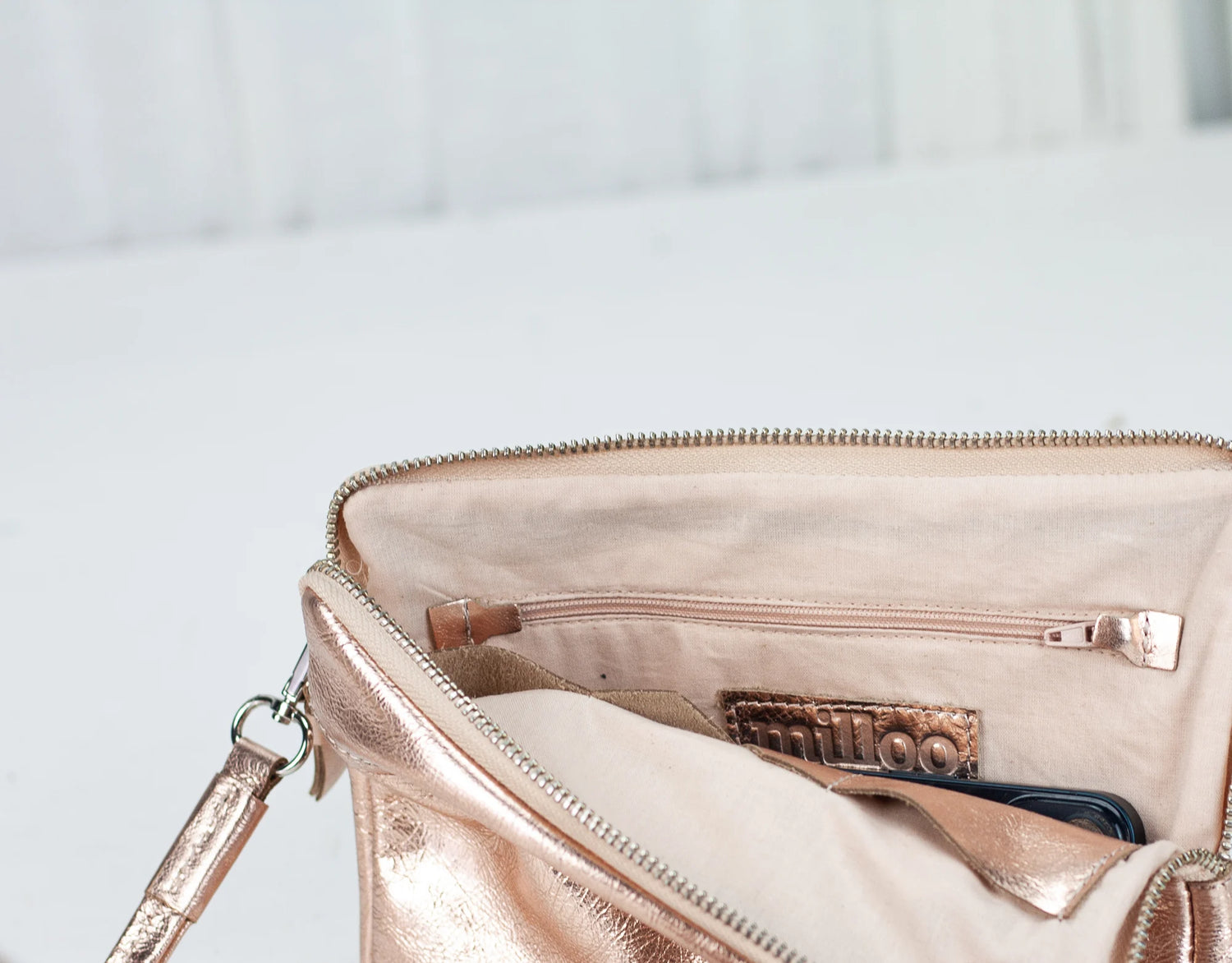 Rose gold handbag with a visible brand logo on a light background