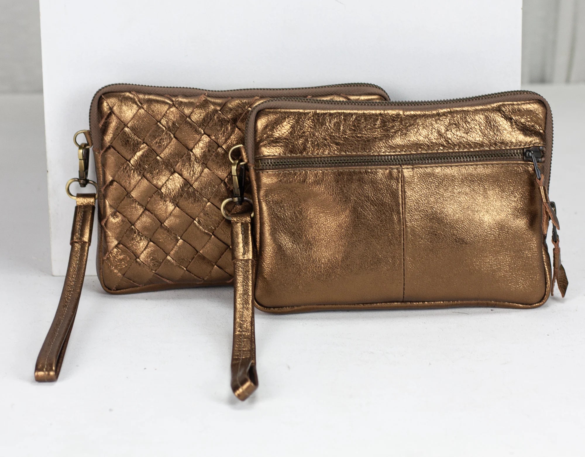 Bronze woven handbag with a strap on a white background