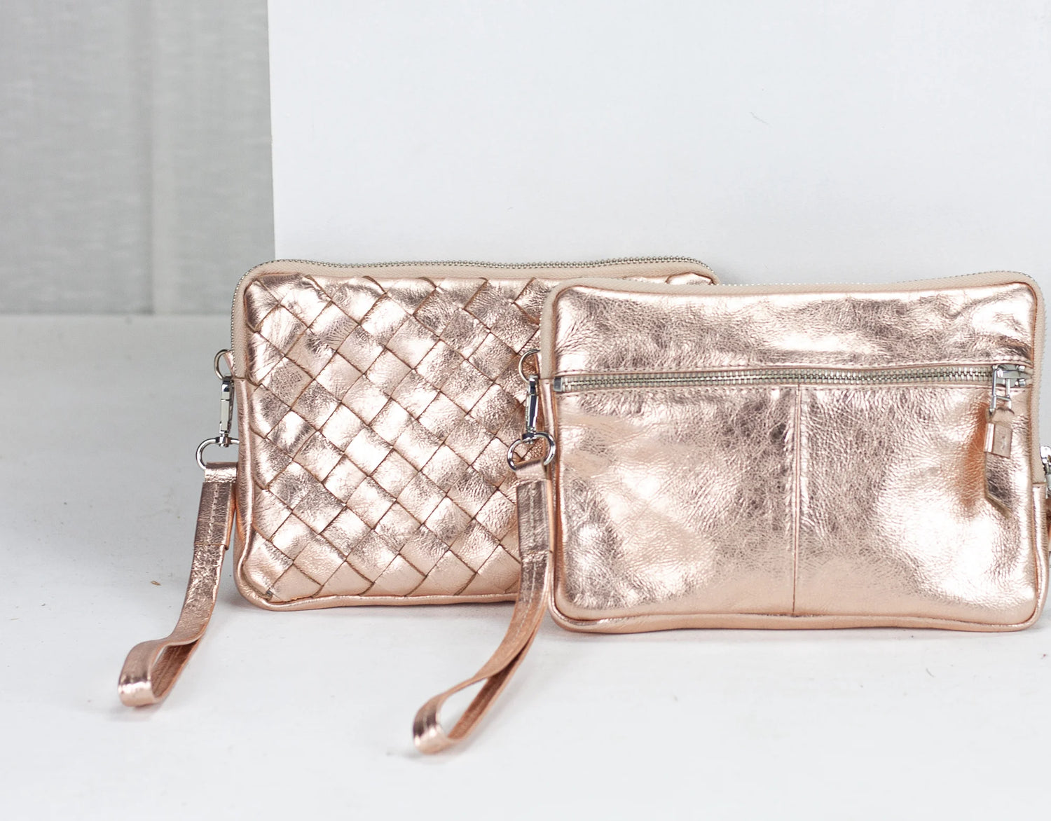 Rose gold handbag and clutch on a white background