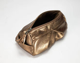 A metallic bronze zippered cosmetic pouch with a tassel zipper pull, photographed on a plain white background.