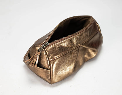 A metallic bronze zippered cosmetic pouch with a tassel zipper pull, photographed on a plain white background.