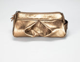 A metallic gold leather pouch bag with a top zipper and a small tassel detail, photographed on a light gray background.