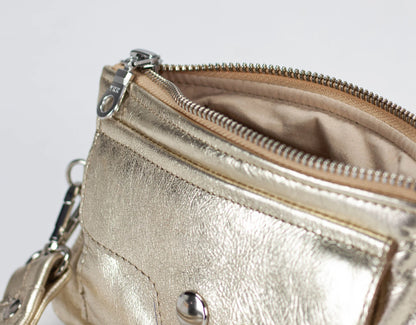Gold metallic handbag with a zipper on a light gray background
