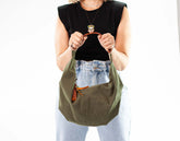Person holding a green bag with a plain background
