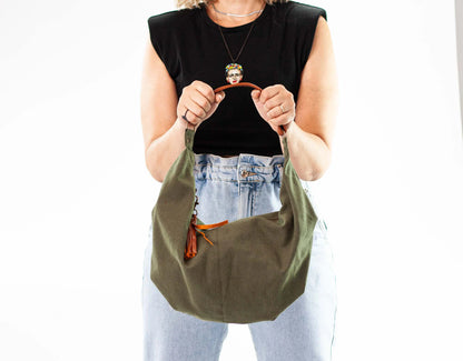 Person holding a green bag with a plain background