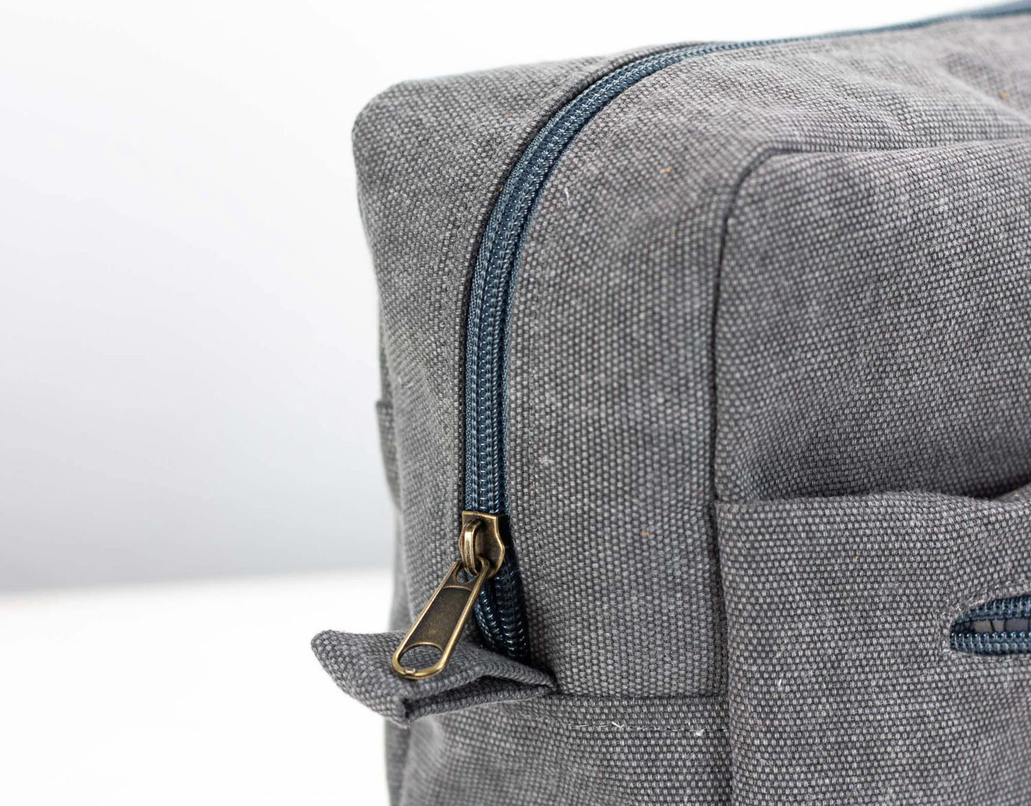 Close-up of a gray textured bag with a zipper on a white background