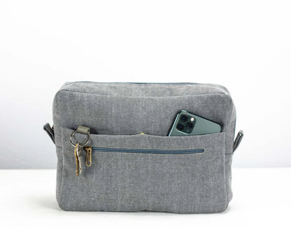 Gray fabric bag with a pocket and key holder on a white background