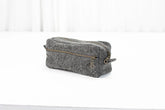 Gray cotton toiletry bag with gold zipper on a white background