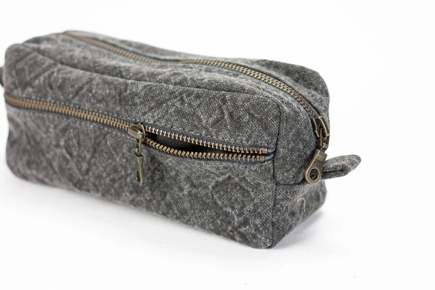 Gray textured toiletry bag with gold zipper on a white background