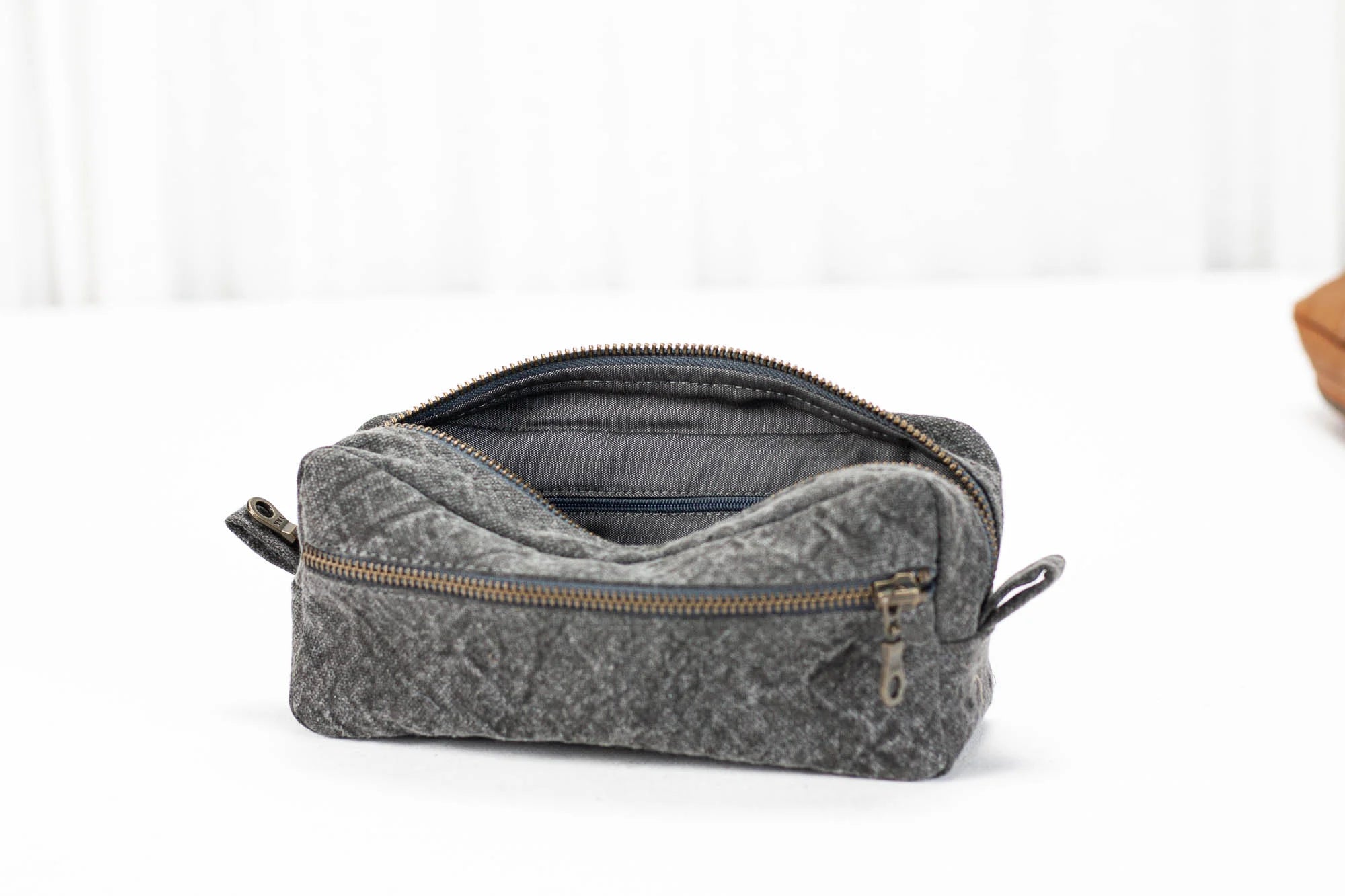 Gray toiletry bag with a zipper on a white background