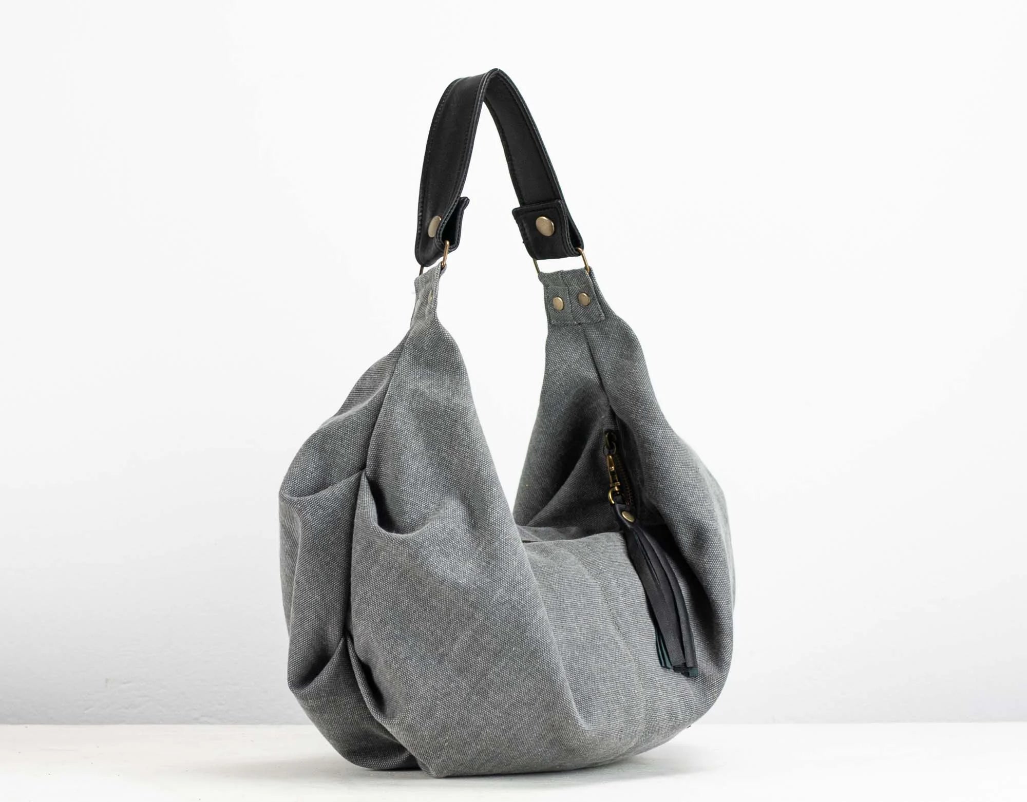 Gray shoulder bag with black handle on a white background