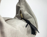 Gray bag with black tassel on a white background