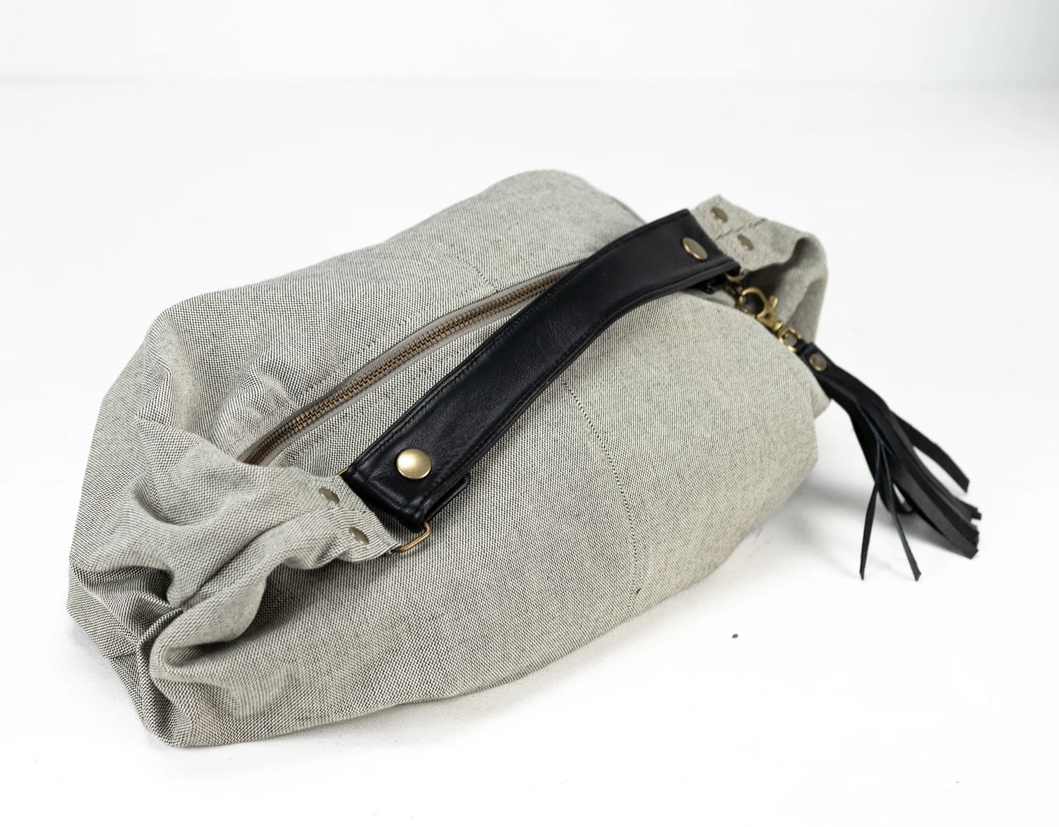 Gray pouch with a black zipper and tassel on a white background