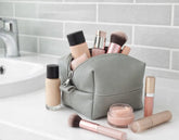 Makeup bag with various makeup items on a bathroom counter