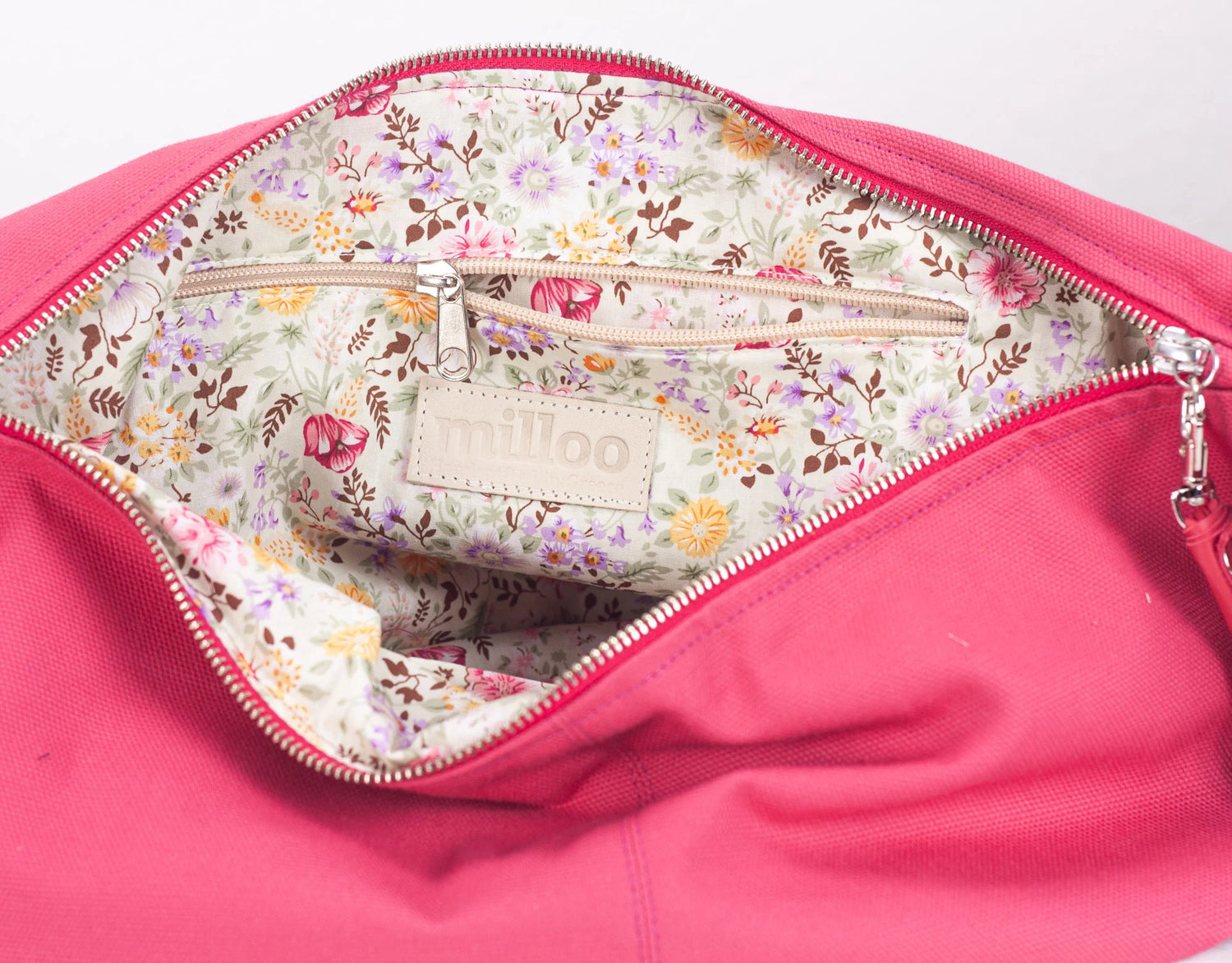 Pink bag with floral interior and visible brand logo on a white background