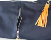 Navy blue bag with a yellow tassel on a light gray background