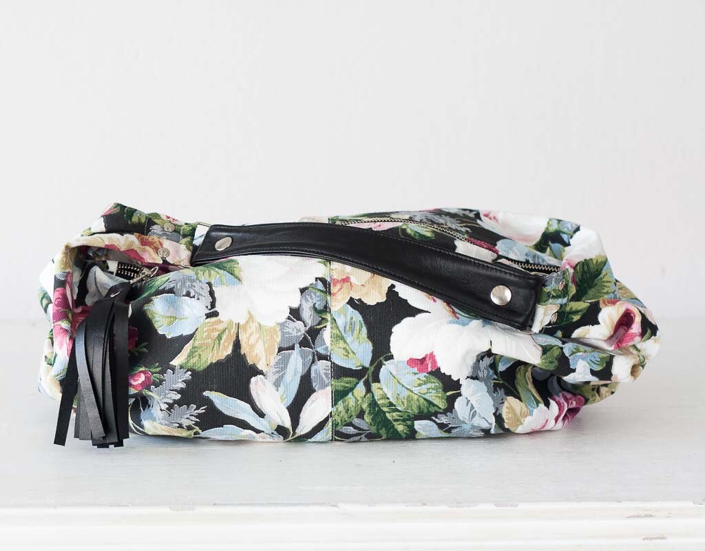 Floral patterned bag with black accents on a white background